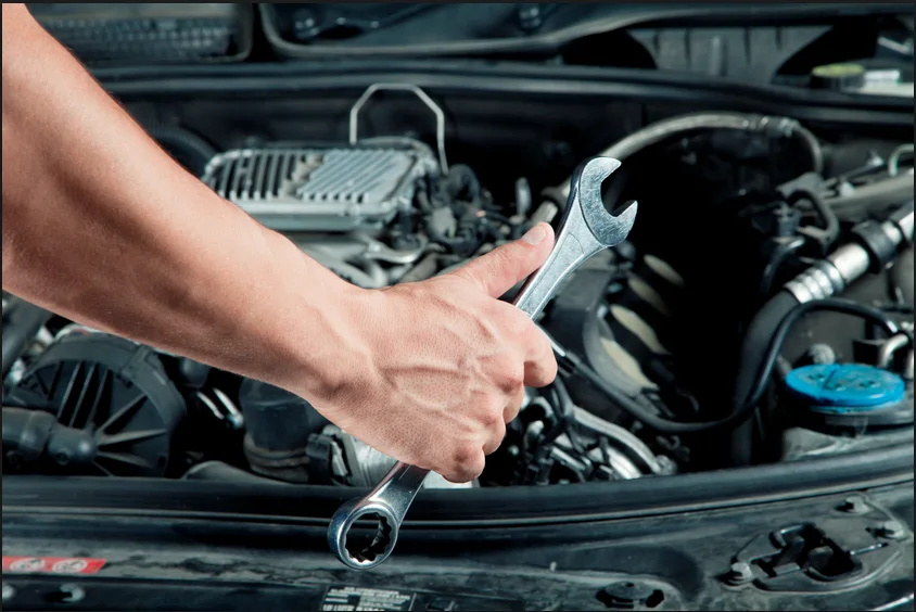 Hands using a tool in an engine bay