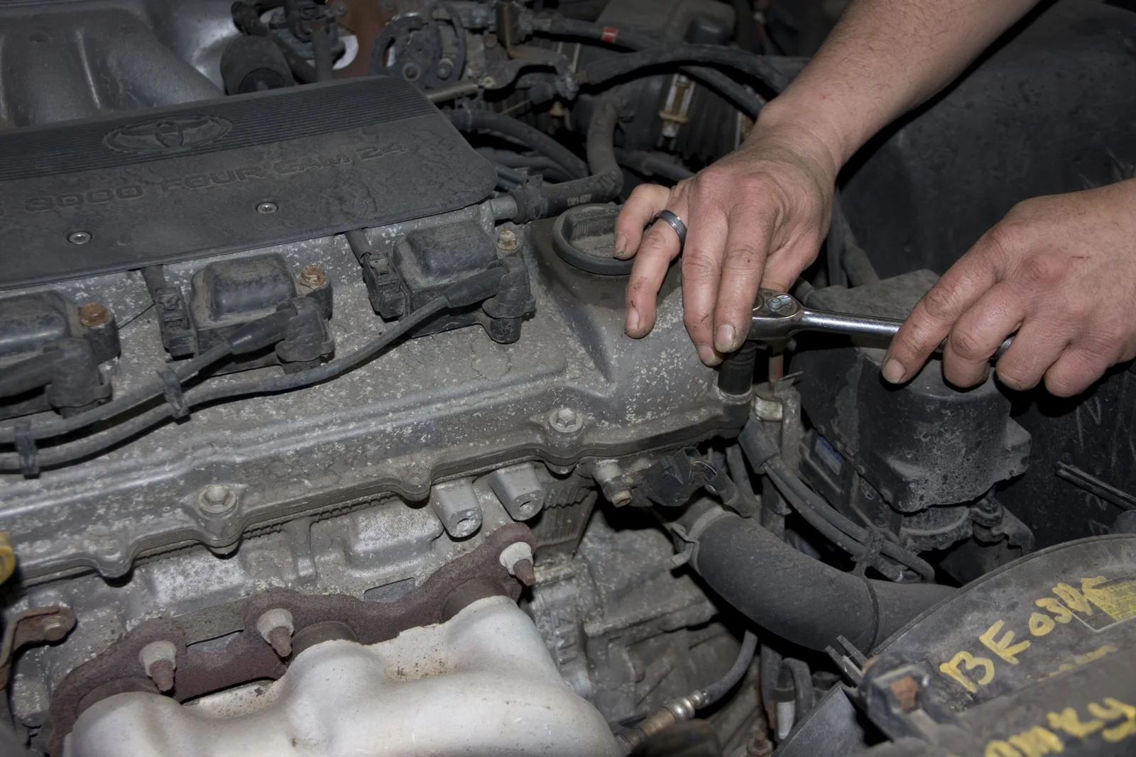 Hands working on an engine in a vehicle